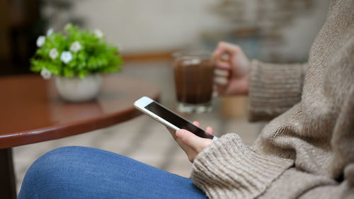 Midsection of woman using mobile phone