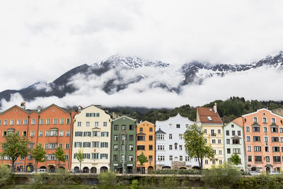 Buildings by mountains against clear sky