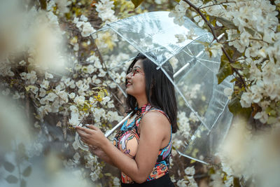 Young woman looking down while standing on plant