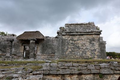 Stone structure against cloudy sky