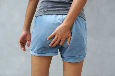 Midsection of woman standing against wall