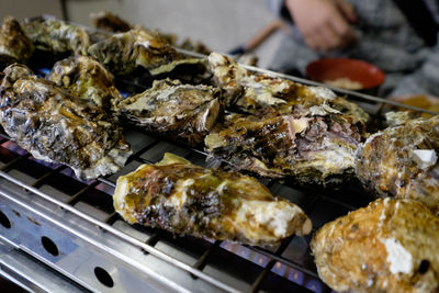 Close-up of oysters cooking on barbecue grill