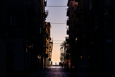Narrow street amidst buildings in city against sky