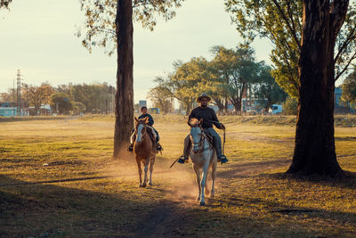 Portrait of father and son riding horse together