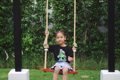 Portrait of happy girl sitting on a swing