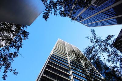 Low angle view of modern buildings against clear blue sky