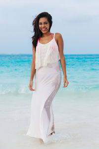 Portrait of smiling woman standing on beach