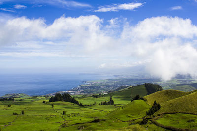 Panoramic view of green landscape against sky