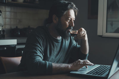 Young man using laptop at table