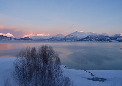 Scenic view of lake and snowcapped mountains against sky