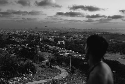 Rear view of woman in city against sky