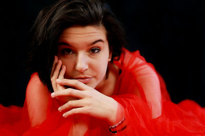 Portrait of young woman with eyes closed against black background