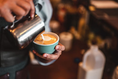 Man pouring coffee in cup