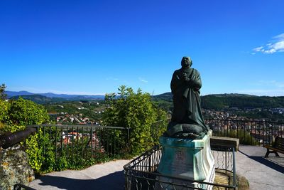 Statue against clear blue sky in city