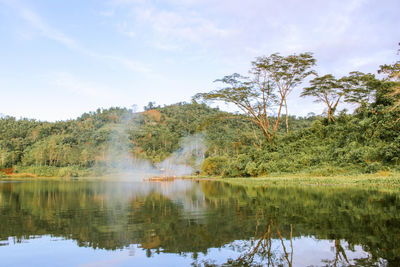 Reflection of trees in lake against sky