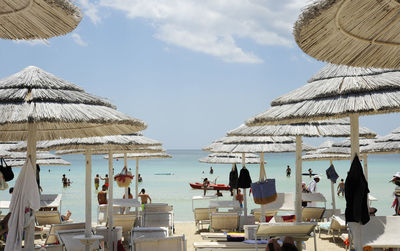 Parasols at beach against sky