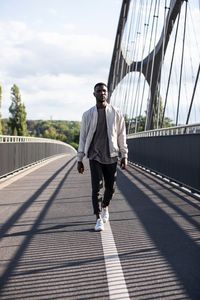 Full length of man walking on footbridge