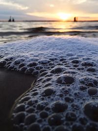 Close-up of sea against sky during sunset