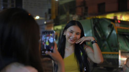 Portrait of young woman in city at night