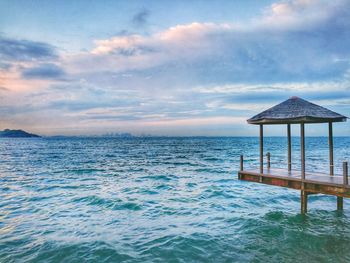 Lifeguard hut on beach against sky during sunset