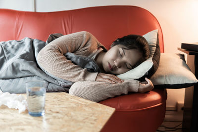 Boy sleeping on bed at home