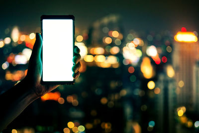 Close-up of hand using mobile phone at night