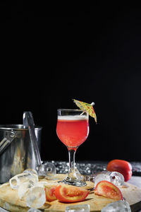 Close-up of wineglass on table against black background