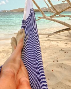 Low section of person in hammock on beach