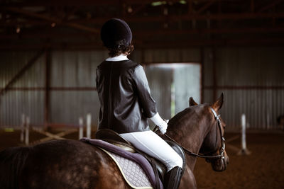 Rear view of man riding horse