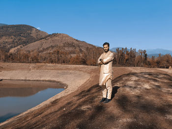 Portrait of man standing on mountain against sky