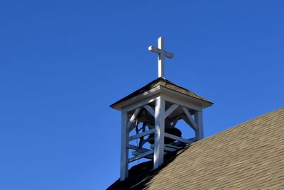 Low angle view of cross against clear blue sky