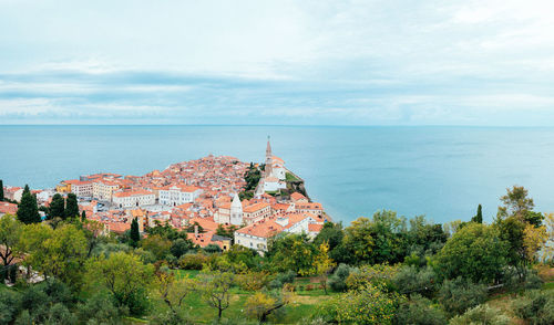 High angle view of townscape by sea against sky