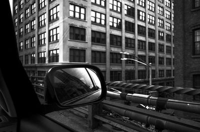 Close-up of car on street against buildings in city