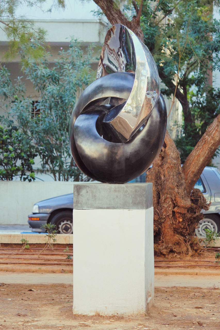 sculpture, art, tree, plant, day, statue, car, monument, mode of transportation, wheel, motor vehicle, no people, wood, nature, transportation, land vehicle, vehicle, metal, outdoors, tire