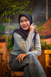 Portrait of smiling young woman sitting on seat