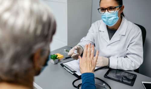 Patient refusing the coronavirus vaccine offered by doctor