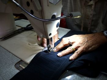 Midsection of woman sticking jeans in workshop