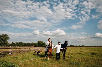 Couple riding horse on field