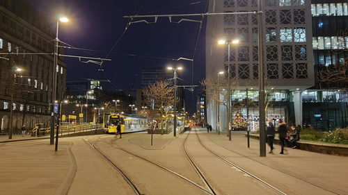 People on illuminated street at night