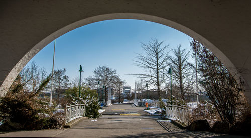 Street amidst trees and buildings against sky