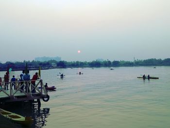 People on boat against sky