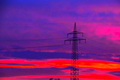 Low angle view of silhouette electricity pylon against sky during sunset