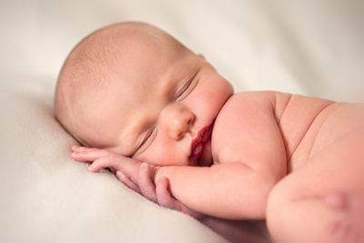 Close-up of baby sleeping on bed