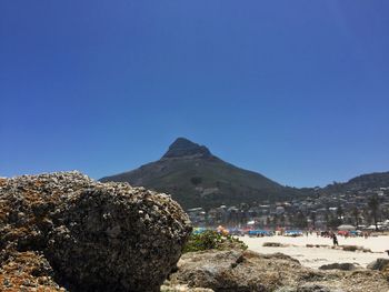 View of people on beach against blue sky