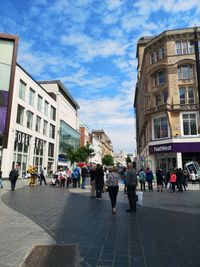 People on street against buildings in city