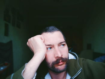 Man looking away while sitting at home