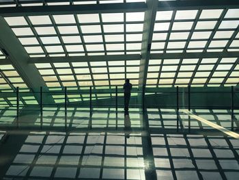 Silhouette of man standing on ceiling