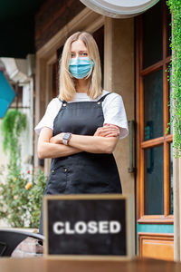 Caucasian waitress woman wearing medical mask, cafe closed. coronavirus covid-19 pandemic