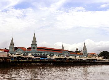 View of river by buildings against sky