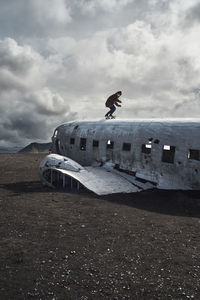 Abandoned airplane on runway against sky